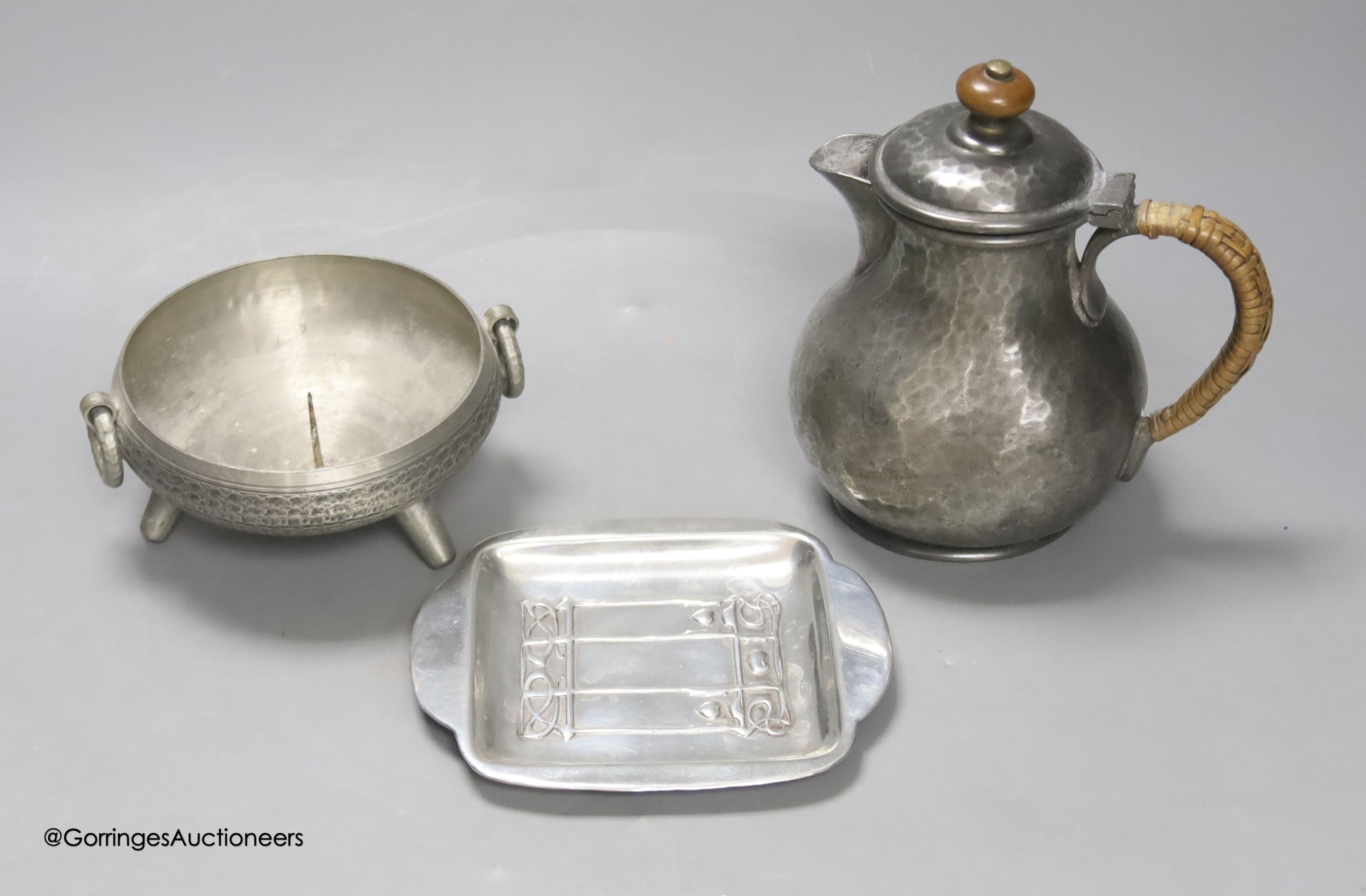 A Liberty & Co Tudric pewter pin dish, a Tudric covered jug and a pewter candleholder
